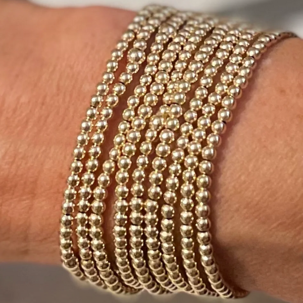 Morgan & Me 4mm 14k Gold Filled Bracelet wrapped multiple times on the wrist, showcasing shiny gold beads with elegant, timeless jewelry style from Knotty and Board.