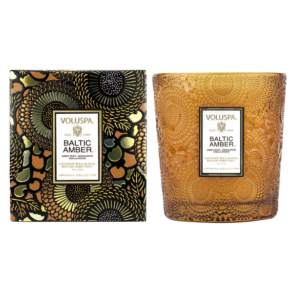 Voluspa Baltic Amber Classic Candle, 9 oz. displayed with its decorative amber glass container and intricately designed black and gold packaging, perfect for home decor and gifts.