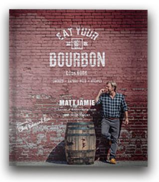 Cover of the Bourbon Barrel Foods Eat Your Bourbon Cookbook featuring a man leaning against a brick wall with a bourbon barrel, capturing a rustic kitchen and entertaining vibe from Knotty and Board.