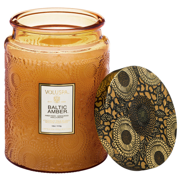 Voluspa Baltic Amber Candle Jar, Large, 18 oz. in an amber glass jar with intricate floral embossed design and matching decorative lid, perfect for home decor and gifts from Knotty and Board.