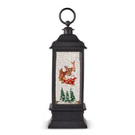 Lighted Water Lantern with Animated Santa Flying, 11 in. features a classic black lantern frame with illuminated scene of Santa in his sleigh flying above snow and pine trees, perfect decor or gifts from Knotty and Board. Every Room Needs A Little Knotty and Board. 1