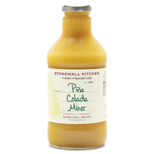 Stonewall Kitchen Pina Colada Mixer, 24 oz. in a clear bottle with a silver cap, featuring pineapple and coconut flavors, perfect for kitchen and entertaining gifts from Knotty and Board.