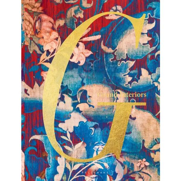 Large golden letter G on a vibrant floral background featuring blue, red, and beige hues, highlighting Grand Interiors decor style with artistic and colorful design.