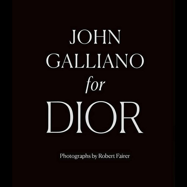 Black background with white elegant typography reading "John Galliano For Dior" and credit to photographer Robert Fairer, reflecting curated decor and unique gifts from Knotty and Board.