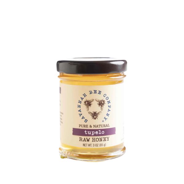 A 3 oz. jar of Savannah Bee Co., Tupelo Raw Honey with a black lid, featuring a simple label displaying bees and natural honey tones, ideal for kitchen gifts and decor.