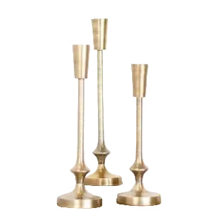 Three elegant Gold Finish Candle Pillar, Medium holders displayed on a surface with books, perfect for adding stylish decor and ambiance to any room.